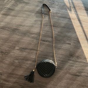 Black purse with gold chain and tassel attachment